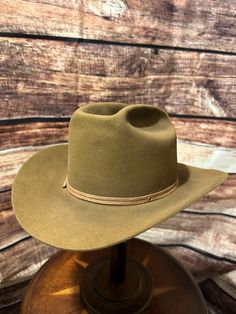 vintage Stetson,  from the mid-20th century, judging by the craftsmanship and the style of the branding. The hat features a light tan or camel-colored felt, a classic wide brim, and a matching hatband. The interior shows the iconic Stetson logo printed on the lining, with an image that appears to be of a cowboy scene, which is common in many vintage Stetson hats. The hat also has leather sweatband detailing. ### Key Features: - **Brand Stetson - **Material Likely a high-quality fur felt, possibl Cowboy Scene, Stetson Hats, Stetson Hat, Golden Tan, Light Tan, Hat Band, Wide Brimmed, Etsy Vintage, Cowboy Hats