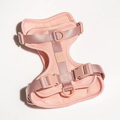 a pink leather dog harness on a white background