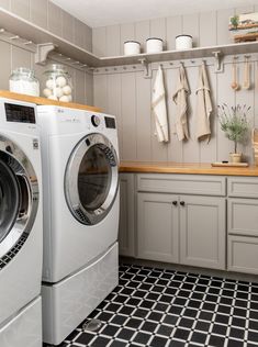 a washer and dryer sitting in a kitchen next to each other on a tiled floor