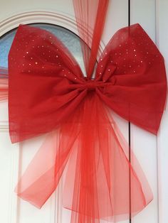 a red bow hanging on the side of a door