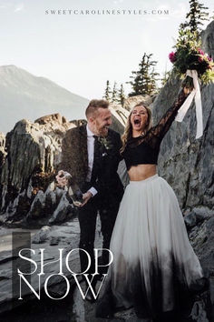 a man and woman standing next to each other on top of a rocky hill with the words shop now