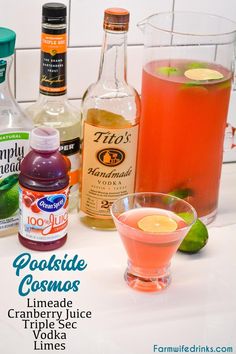 some drinks are sitting on a counter with limes and other ingredients in the background