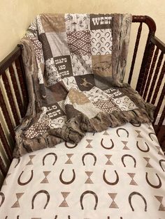 a baby crib with a blanket on top of it and a pillow in the middle