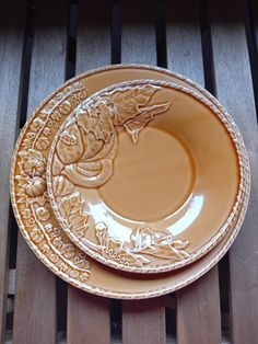 two brown plates sitting on top of a wooden table