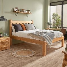 a bed room with a neatly made bed next to a wooden table and chairs in front of a window