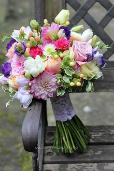 a bridal bouquet sitting on top of a wooden bench