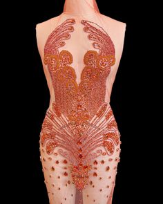 the back of a woman's body in an orange and pink dress with sequins on it