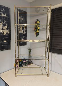 Vintage Brass and Glass Shelf. Stunning 4 Tier Brass Shelf with Clear Glass Panels and arched top. Definitely the Hollywood Regency Vibe. Universal appeal for nearly every room in your home. Approximately 4 feet tall.  In great vintage condition, some typical brass patina. Glass pieces are in excellent condition.  No missing feet caps or glass protectors.  Very sturdy.  Will be disassembled for safe shipping. Please know that I am not an expert and i ask you to view my photos as I have added man Brass Shelves, Glass Protector, Brass Patina, Furniture Bookshelves, Glass Shelves, Plant Stand, Display Shelves, Glass Panels, Shelving Unit