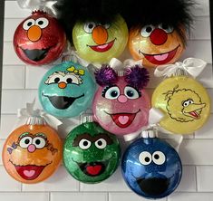 the sesame street ornaments have been painted to look like cartoon characters and are hanging on a wall