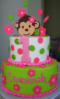 a green and pink birthday cake with a monkey on top