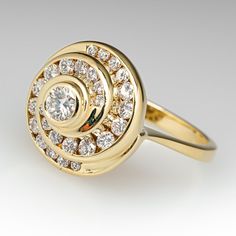 This gorgeous diamond swirl ring is centered with a round brilliant cut diamond in a full bezel setting. The center is surrounded by a swirl design, channel set with a total of twenty-six (26) slightly graduated, round brilliant cut diamonds. The ring measures 15.0mm at the top, rises 11.1mm above the finger, tapering to 2.4mm wide and 1.3mm thick at the base of the shank. The ring is currently a size 6.75. Elegant Spiral Yellow Gold Diamond Ring, Luxury Spiral Diamond Ring, Elegant Spiral Diamond Ring, Swirl Diamond Ring, Swirl Ring, Bezel Set Diamond, Swirl Design, Channel Set, Round Brilliant Cut Diamond