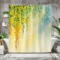 a shower curtain with yellow and green leaves hanging from it's side in a bathroom