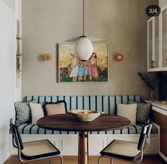 a dining room table with two chairs and a painting on the wall