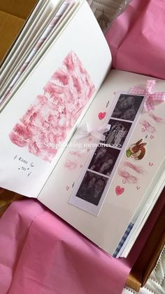 an open book with pink paper and pictures on it