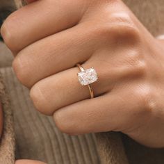 a woman's hand with a diamond ring on it