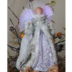 an angel figurine sitting on top of a christmas tree