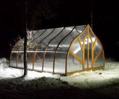 a small greenhouse in the snow at night