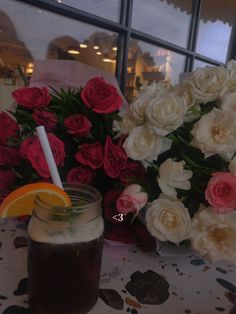 there is a drink and flowers on the table