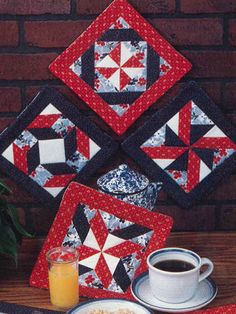 four red and white quilted coasters, one with a coffee cup on it