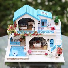 a doll house with a pool in the middle and flowers on the balcony above it