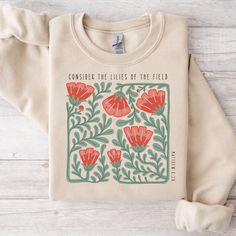 a t - shirt with an image of red flowers on the front and green leaves on the back