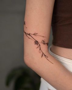 a woman's arm with a small tattoo design on the left side of her arm