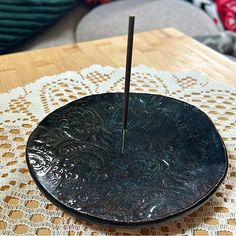 a black plate sitting on top of a wooden table