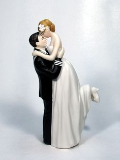 a figurine of a bride and groom kissing on the cheek, with white background