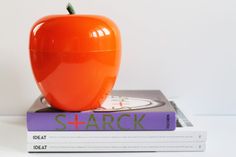 an orange apple sitting on top of two books with the word shark written underneath it