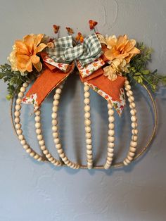 a wreath with flowers and wooden beads hanging on the wall