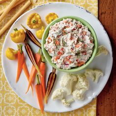 a white plate topped with carrots, cauliflower and other foodstuffs