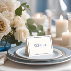 a place setting with white roses and candles