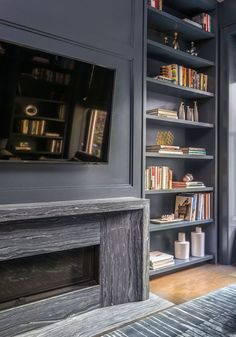 a living room with bookshelves and a television mounted on the wall above it