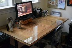 a desk with a computer on it in front of a window and other office supplies