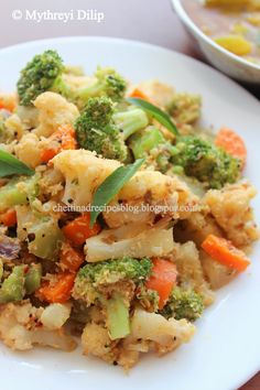 a white plate topped with broccoli and cauliflower