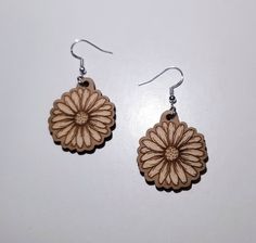 a pair of wooden dangles with flowers on them are sitting on a white surface