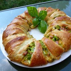 a croissant filled with meat and vegetables on a plate