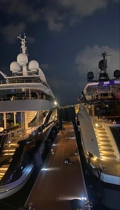 two cruise ships docked at night with lights on them