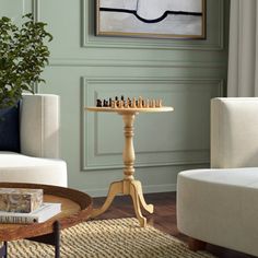 a living room filled with furniture and a painting on the wall over a coffee table