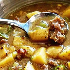 a spoon full of soup with potatoes and meat