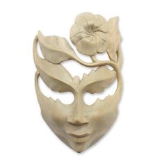 a white mask with flowers on the side and leaves in the middle, against a white background