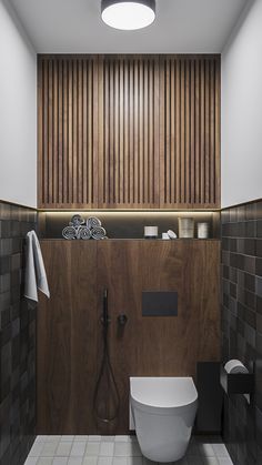 a modern bathroom with wood paneling and tile walls, along with a white toilet