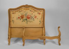 an old fashioned wooden bed with flowers painted on it