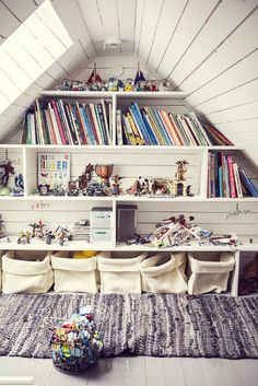 an attic bedroom with bookshelves filled with toys