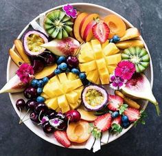 a white bowl filled with lots of different types of fruit on top of a table