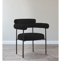 a black chair sitting on top of a hard wood floor next to a white wall