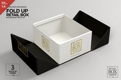 an open black and white box with gold foil on the lid is sitting in front of a gray background