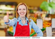 a woman in an apron giving the thumbs up