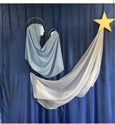 a blue curtain with white drapes and a yellow star hanging from it