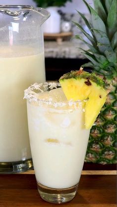 a pineapple drink next to a glass of milk